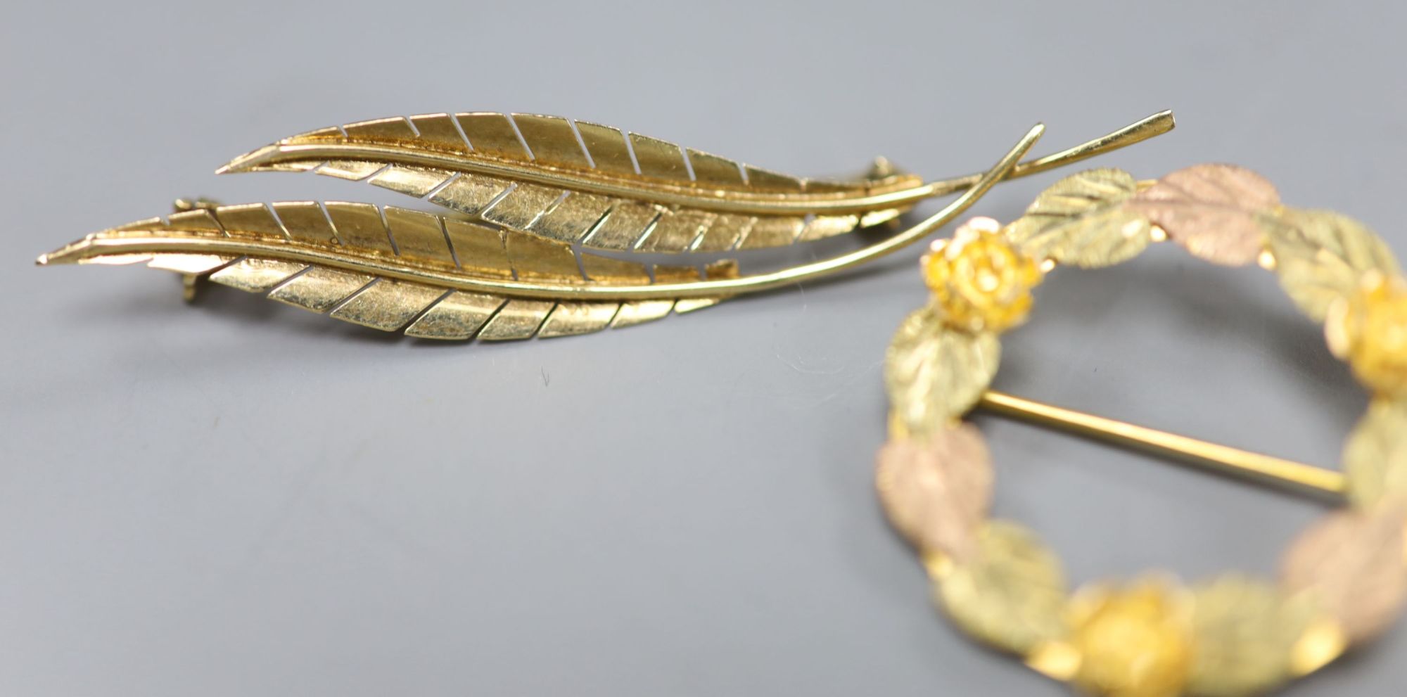 A 585 yellow metal double leaf brooch, 51mm a 9ct gold leaf brooch and a 10k tri-colour foliate wreath brooch (3)